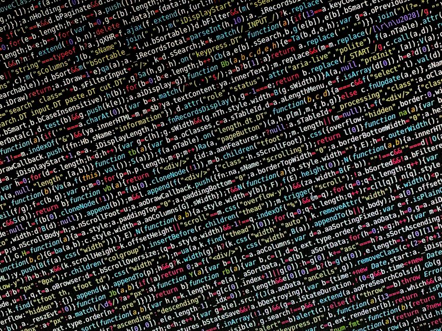 A close-up photograph of a computer screen displaying a code editing environment with an HTML document open. Visible code lines include the doctype declaration, opening html tag with language attribut